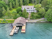 Built in 1964, the Skaneateles Lake home at 2880 West Lake Road "perfectly" accommodated Sylvia Goetzmann's antique collections. Aerial view of the property, including the vintage boathouse and grassy area on the left where her family has barbecues and visits. Courtesy of Rick Policastro Photography