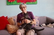 Alisha Reynolds, owner of Pawsitivitea CNY Cafe & Cat Lounge, sits with Freddie Purrcury, a permanent resident of the Syracuse cat cafe. (Katrina Tulloch)