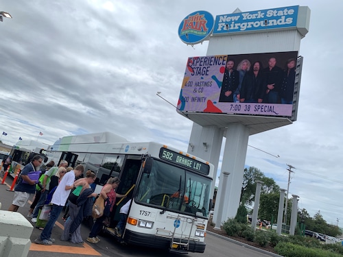 Passengers climb aboard a bus