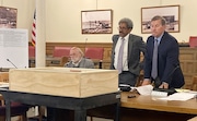 Syracuse City Planning Commission members Steven Kulick, right, and Walter Bowler stand up to look at a piece of the exterior facade from the mansion at 727 Comstock Ave. brought to their meeting Monday, July 29, 2024, by Syracuse University. The university is seeking to demolish the structure, while the city considers its historic value. (Jeremy Boyer I JBoyer@syracuse.com)