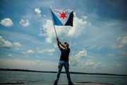 Eric Hart waves his "First Light" flag that he designed for Syracuse at Onondaga Lake Park in Liverpool. Wednesday, June 5, 2024. (N. Scott Trimble | strimble@syracuse.com)