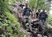 11 rangers carry out a 15-year-old hiker who broke his leg on Aug. 5 at the junction of Wright and Algonquin peaks, in the Adirondack High Peaks region.