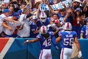 Buffalo Bills linebacker Terrel Bernard, center, celebrates with fans and teammates Dorian Williams (42) and Matt Milano (58) after intercepting a pass during the first half of an NFL football game against the Las Vegas Raiders, Sunday, Sept. 17, 2023, in Orchard Park, N.Y. (AP Photo/Jeffrey T. Barnes)