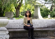 Anne Marie Higgins sits on a memorial bench in Oakwood Cemetery below a fir tree once favored by SU-Sue and Otto, a beloved pair of red-tailed hawks that died within days of each other in January 2023.