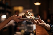 Waitress's hand  giving food order to a customer